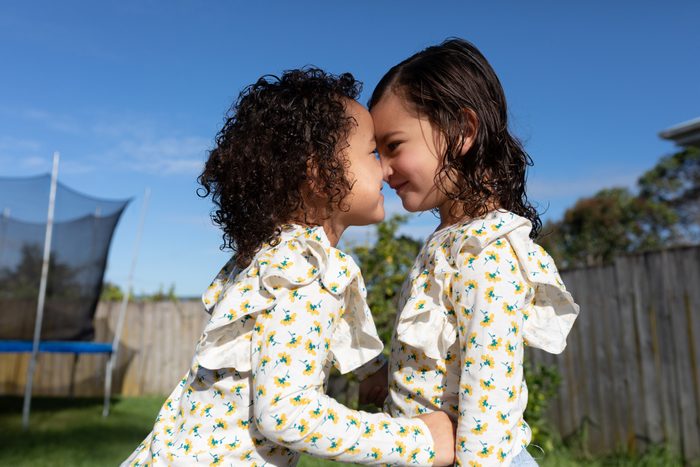 Twin sisters giving each other a hongi