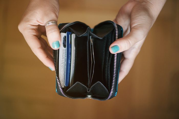 close up of manicured hands holding open a wallet with credit cards inside in the credit card slots