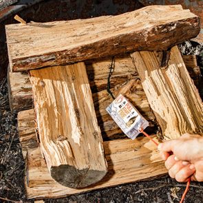 Logs are stacked, surrounding a fire starter labeled 
