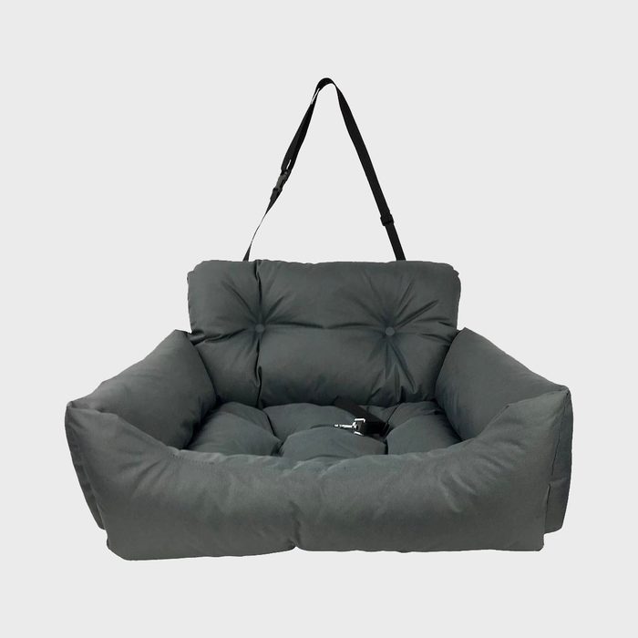 Plush pet seat with strap rests against a white background, featuring soft cushioning and tufted button details.