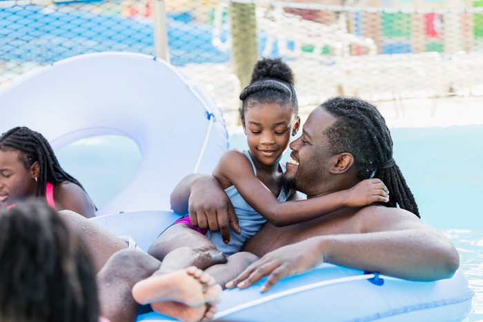 African-American girl, father on water park lazy river