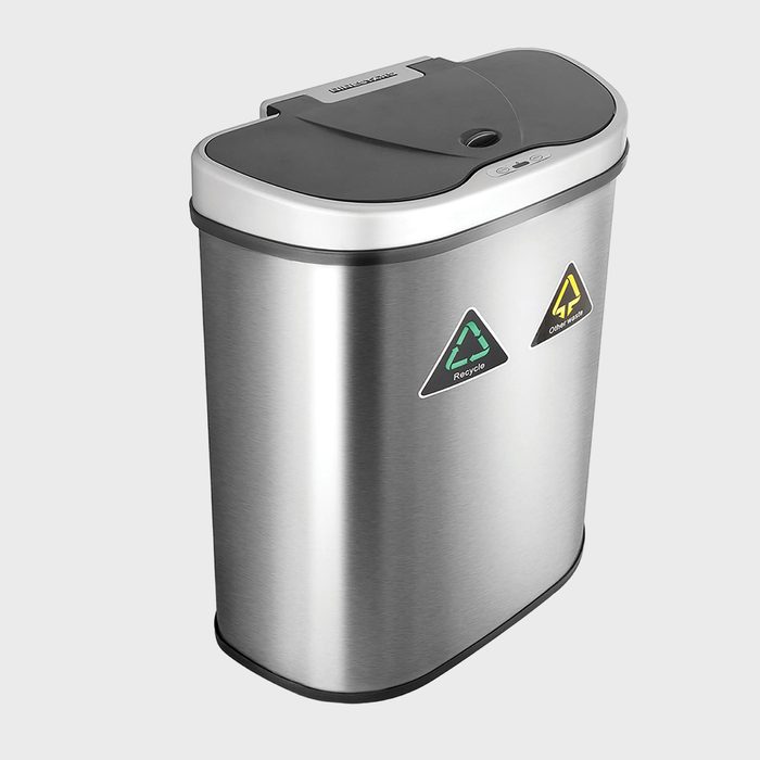 Metal trash can with dual recycling symbols, featuring a black lid, situated on a plain gray background.