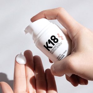 Hands dispense white cream from a 