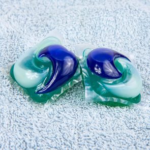 Two colorful laundry pods resting on a soft, textured towel surface.