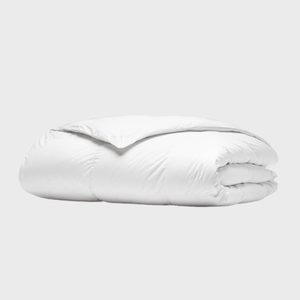White comforter neatly folded, resting on a plain, light gray background.