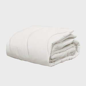A neatly folded white comforter rests on a plain, light gray surface.