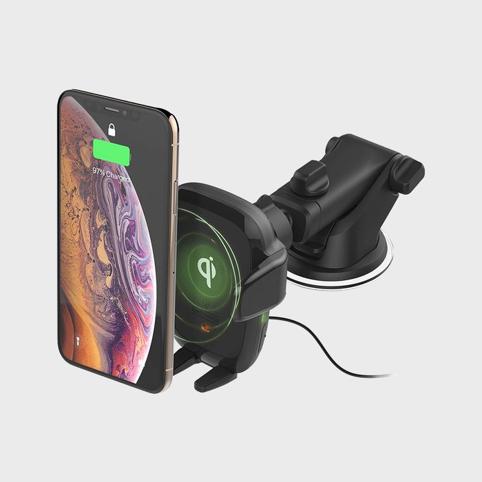 Phone charges wirelessly on a black mount with an attached suction cup, displaying 