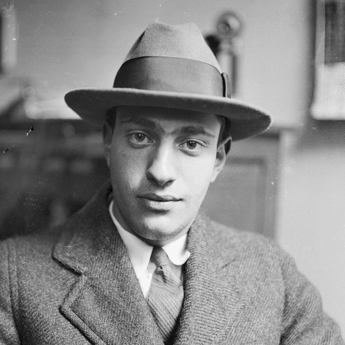 Nathan Leopold sitting with his hat on and looking at camera