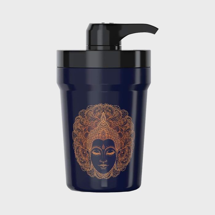 Bottle with pump cap, featuring an ornate golden face design, set against a plain light gray background.