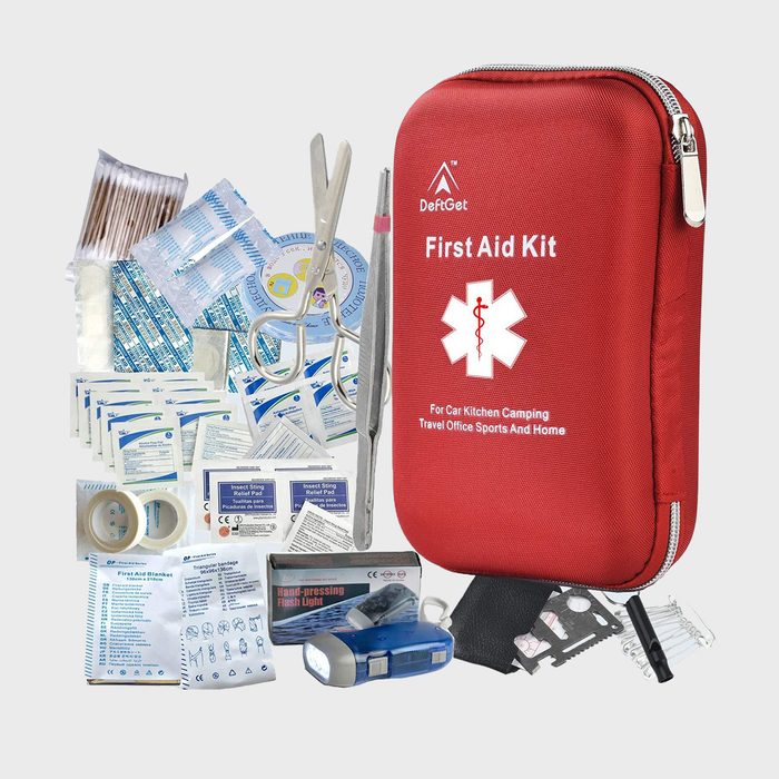 Red first aid kit displayed with medical supplies; includes scissors, tweezers, bandages, tape, and flashlight. Suitable for car, kitchen, camping, and more.