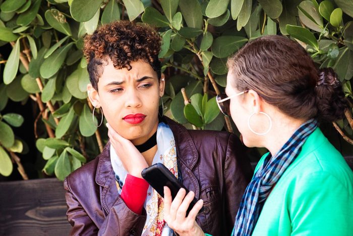 Hip young urban female doubting her friend's text message