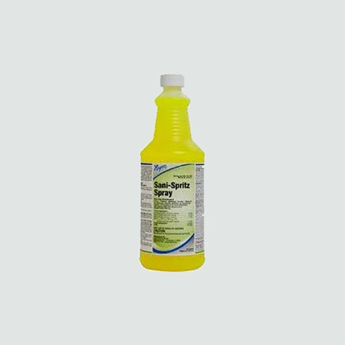 Yellow spray bottle standing upright, labeled 