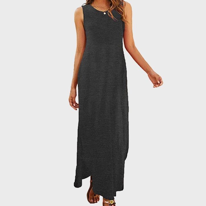 A person wearing a sleeveless black maxi dress stands against a plain white background.