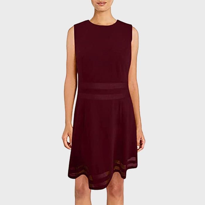 A sleeveless, dark red dress is being worn by a person standing against a plain gray background.