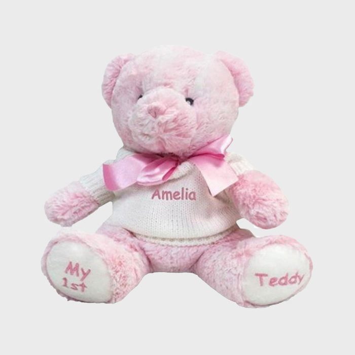 Pink teddy bear sits wearing a sweater and bow, surrounded by plain background. Text reads: 