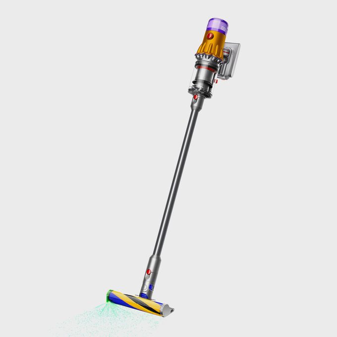 Cordless vacuum standing upright, with a sleek design, emitting green light, against a plain white background.