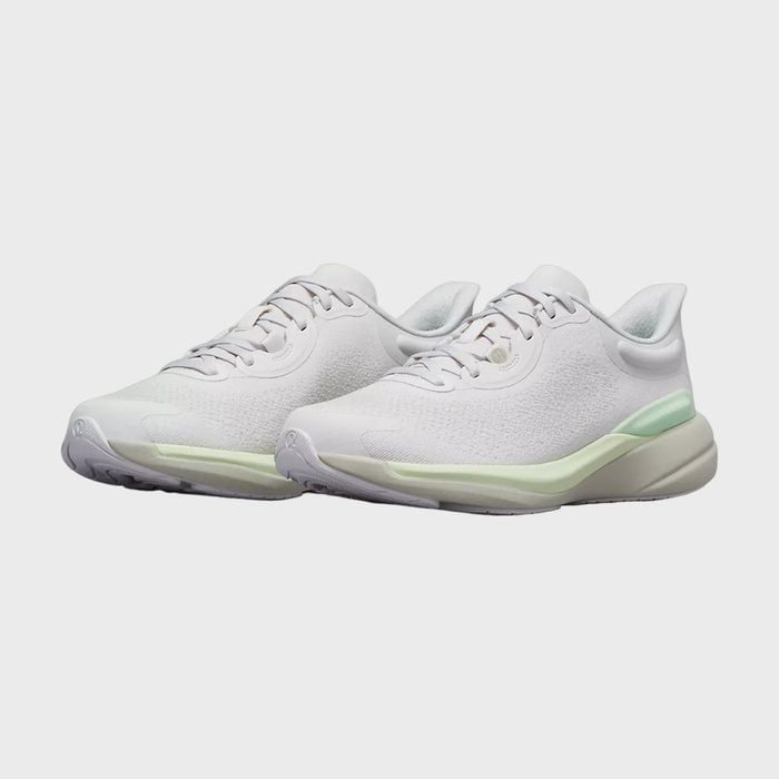 White sneakers with mint green accents rest on a plain white background.