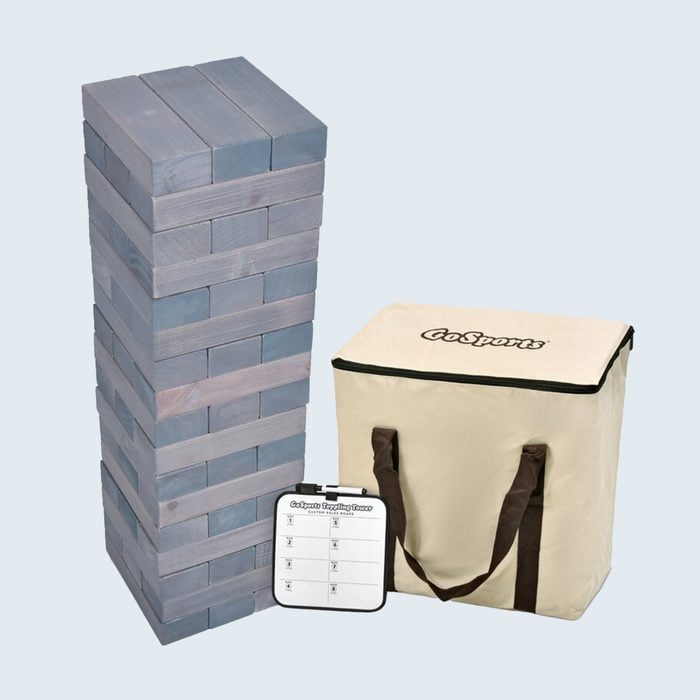 A stacked block tower stands next to a canvas bag and scorecard in a plain environment. The bag reads 