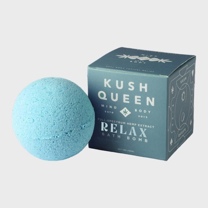 A blue bath bomb sits beside a box labeled 