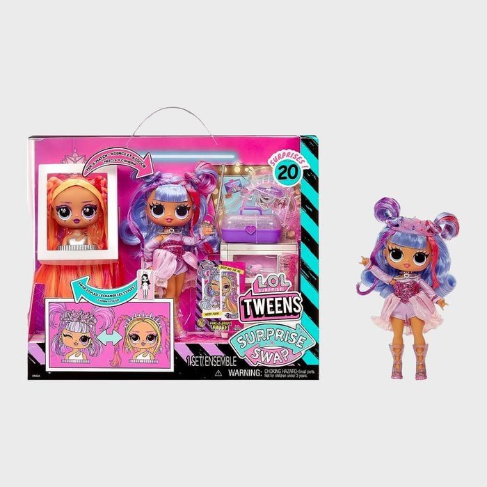 Doll stands with colorful hair and outfit, packaged alongside accessories. Bright, decorative box displays 