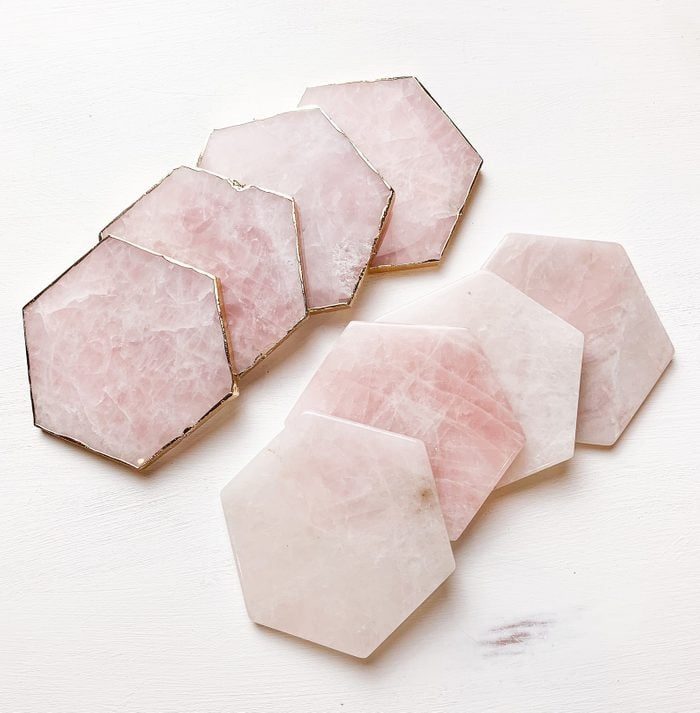 Hexagonal pink stone coasters are arranged in overlapping layers on a plain white background.