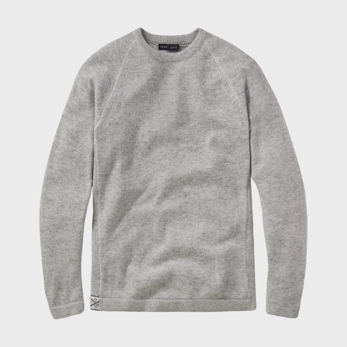 Gray sweater lies flat against a plain white background, displaying its simple design and soft material texture.