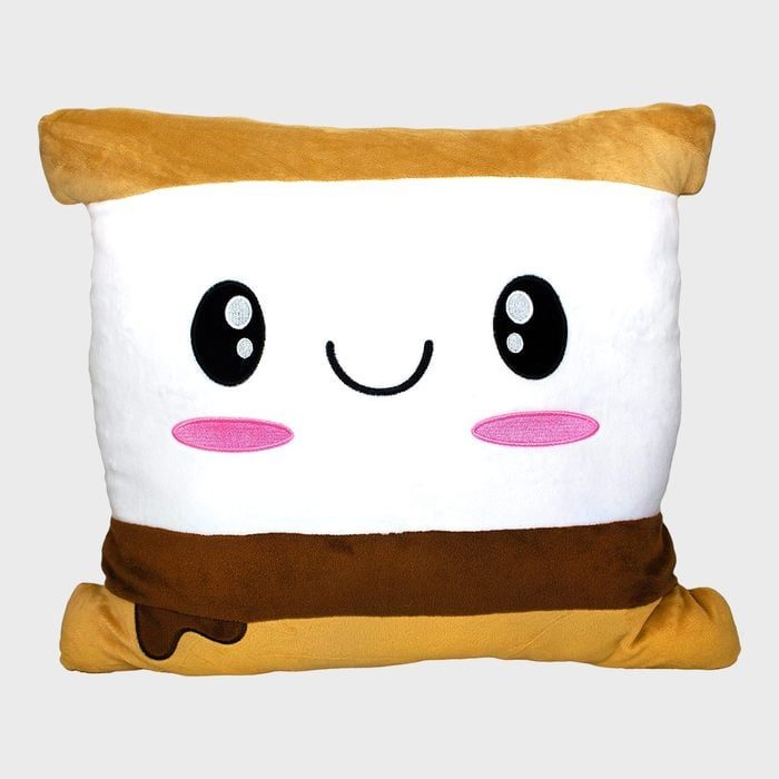 A square plush pillow features a kawaii smiling face with large eyes and pink cheeks, resembling a s'more dessert, against a plain background.