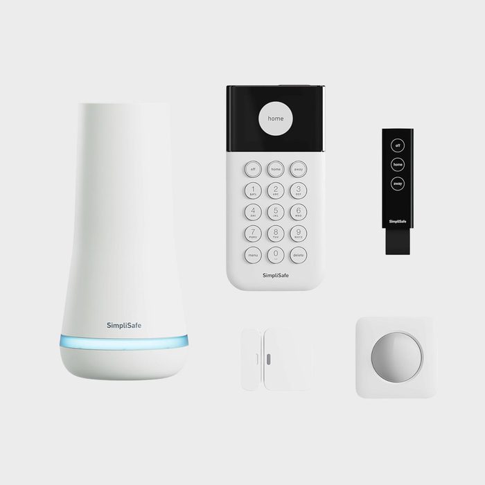 A SimpliSafe home security system displayed with a keypad, remote, sensor, and siren against a plain background.