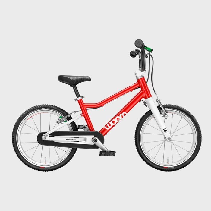 Red children's bicycle standing, featuring small wheels and labeled 
