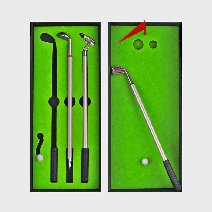 Golf-themed pen set displayed, including three pens shaped like clubs and a small ball, in a black case with green felt lining.