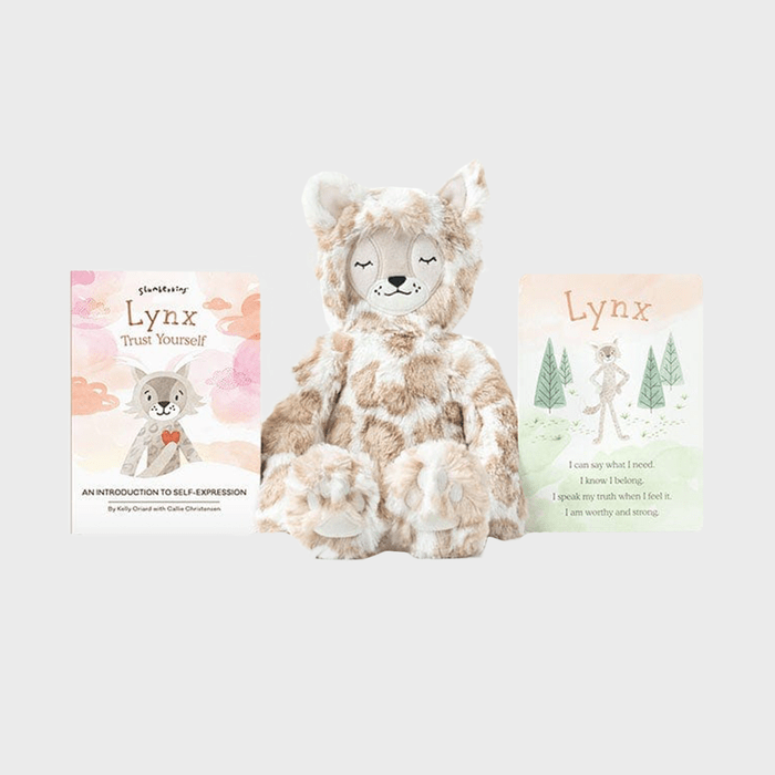 A plush lynx sits between two illustrated cards with text related to self-expression and affirmation, against a light gray background.