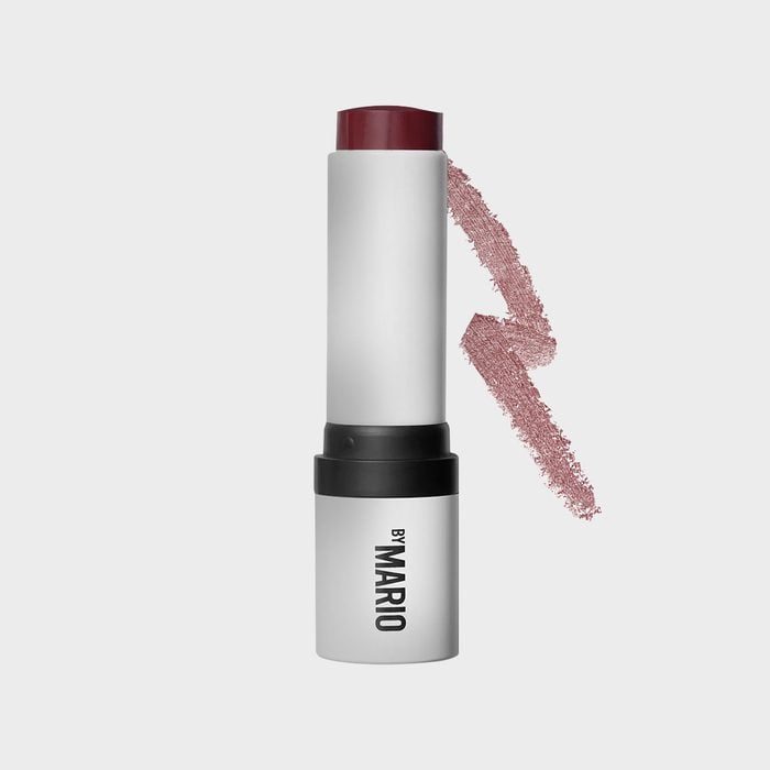 A lipstick twists upward, showing its deep red color against a light gray background. The label reads 