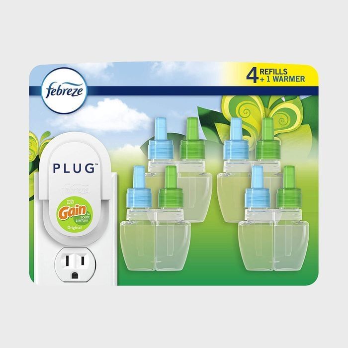 Air freshener plug-in set includes one warmer and four refills. Background shows leafy patterns and blue sky. Text: 