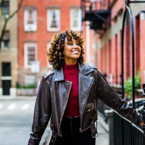 Smiling woman walks down a city street