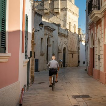 Elderly man on bicycle on a charming Mediterranean street