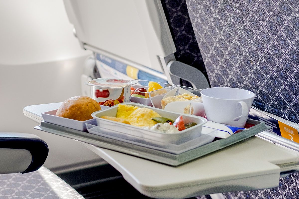 Tray of food on the airplane in the cabin economy class.
