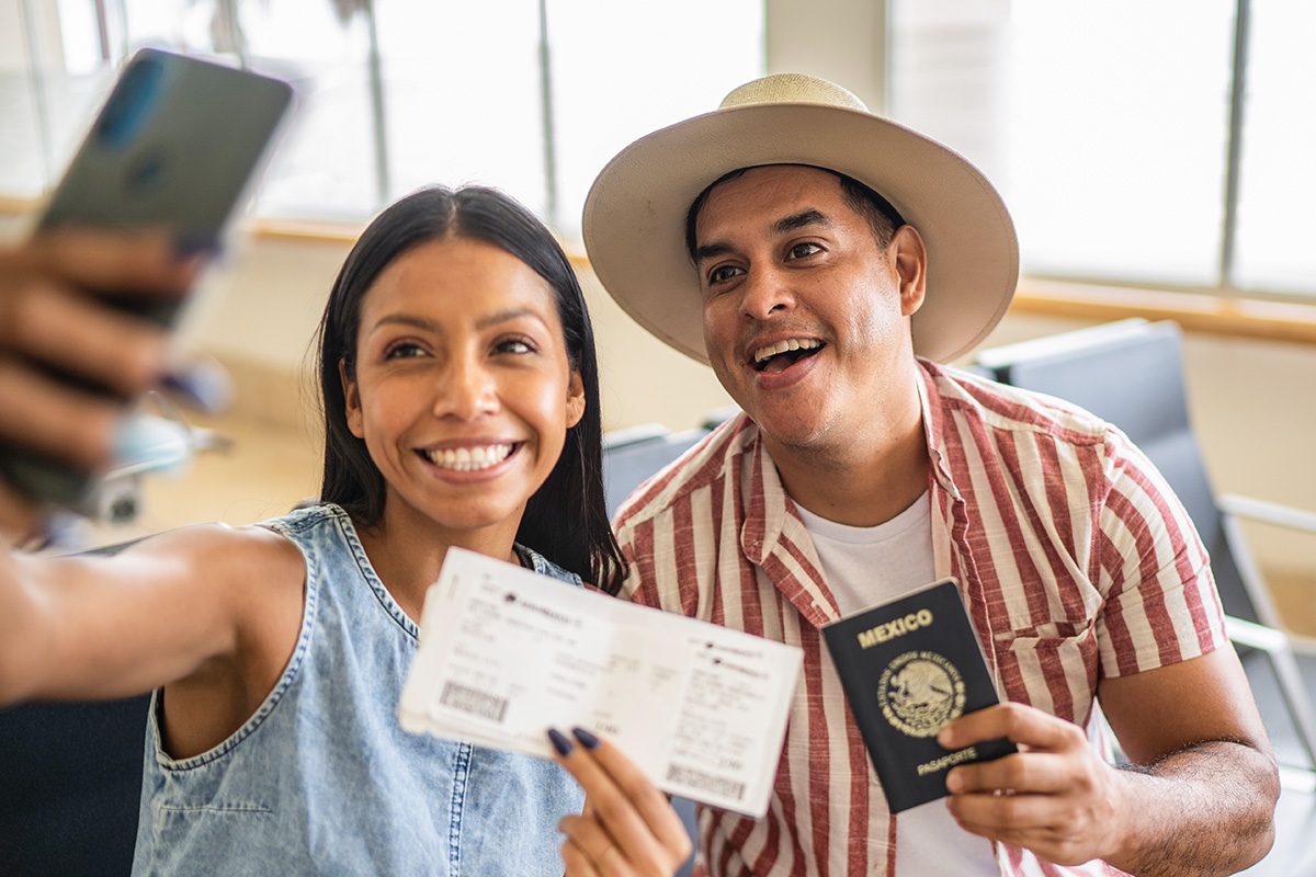 Couple taking a selfie with passport and airplane ticket