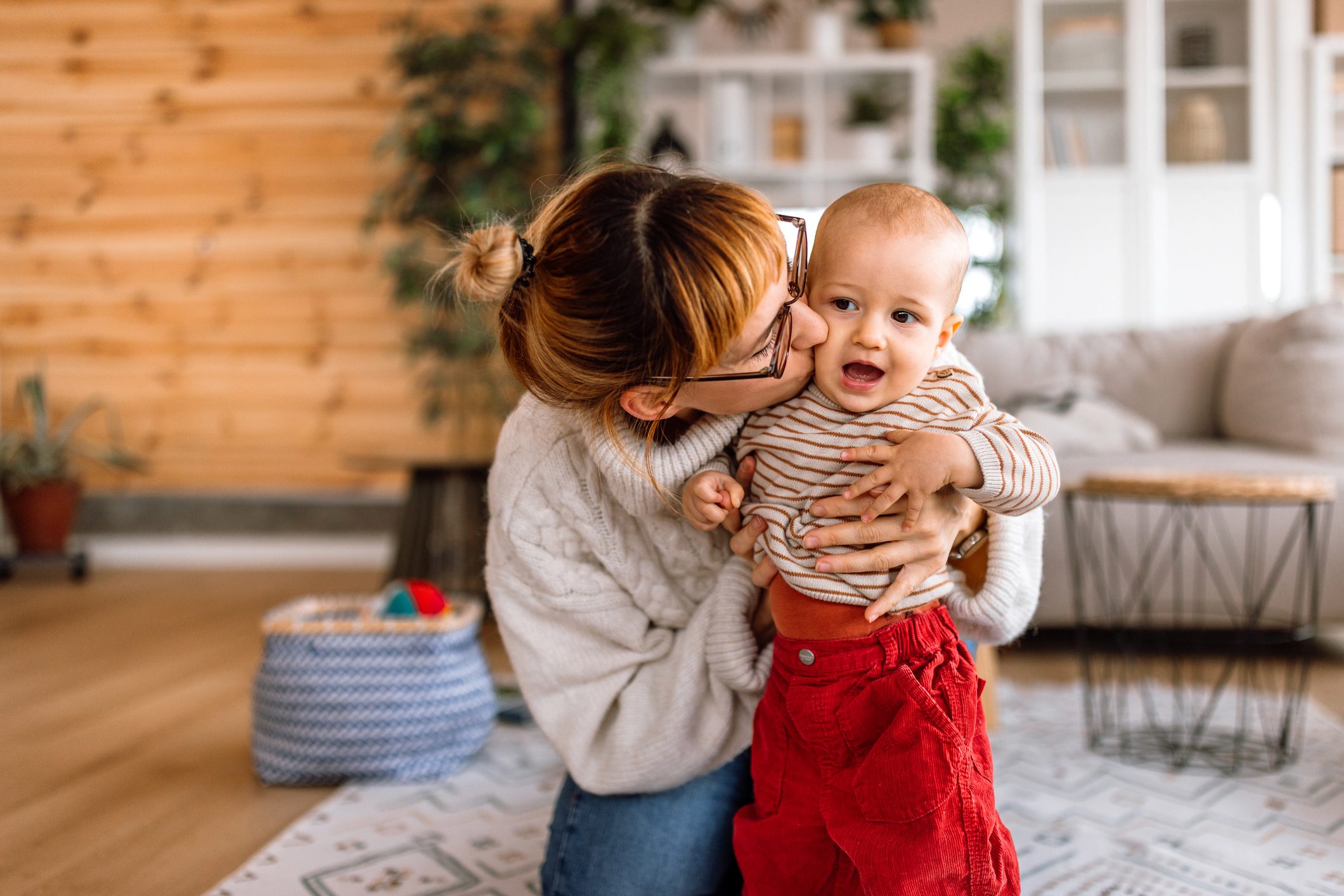 Mother kissing cute little baby boy