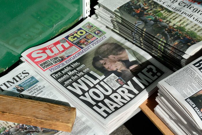 A variety of daily newspapers, including The Sun, for sale at a newstand in London, England. The Sun's headline refers to Prince Harry and his girlfriend, Meghan Markle