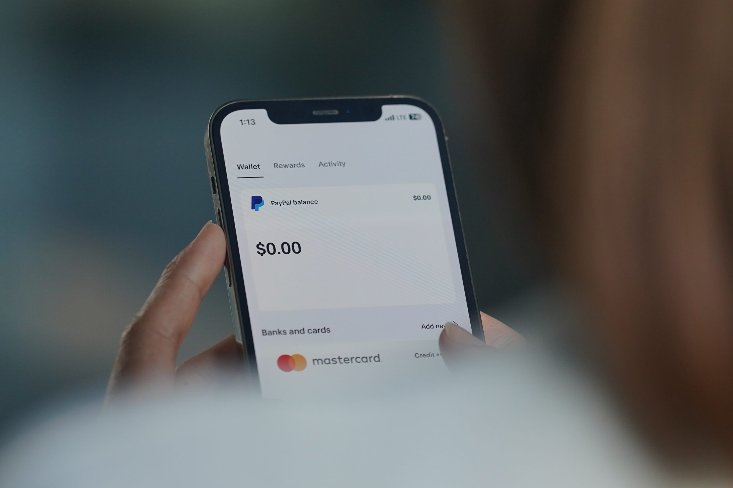 Close up of person holding a phone with the PayPal app